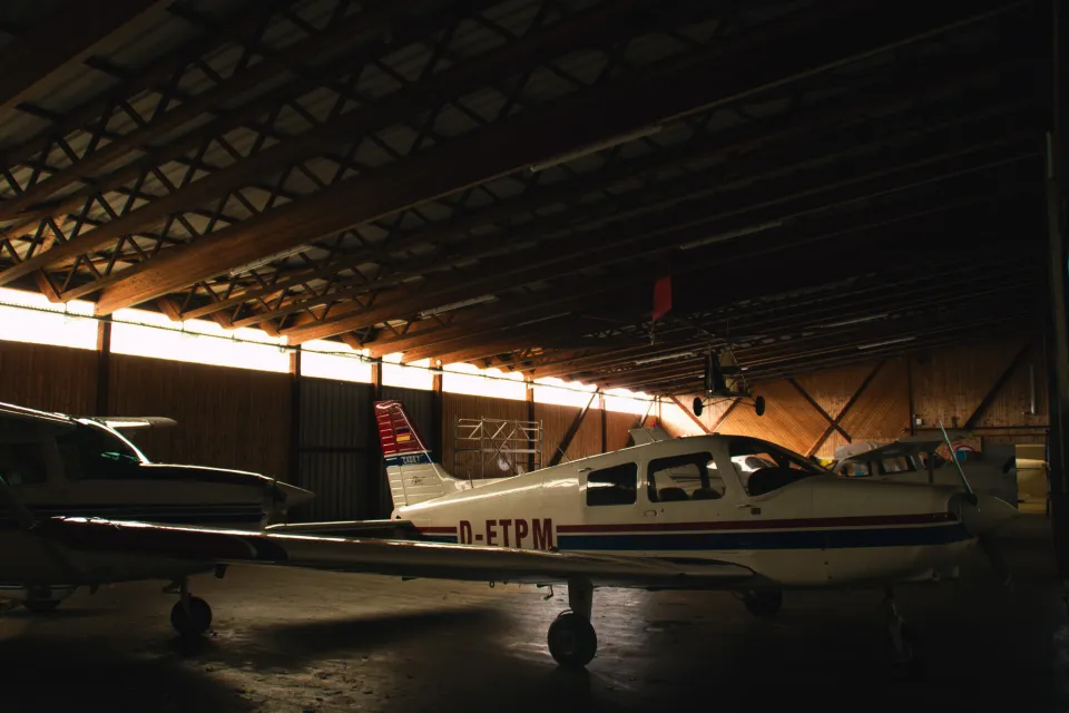 Hangar mit Piper Cadet im Gegenlicht