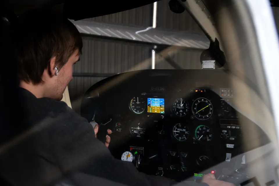 Junger Pilot am Steuer im Cockpit