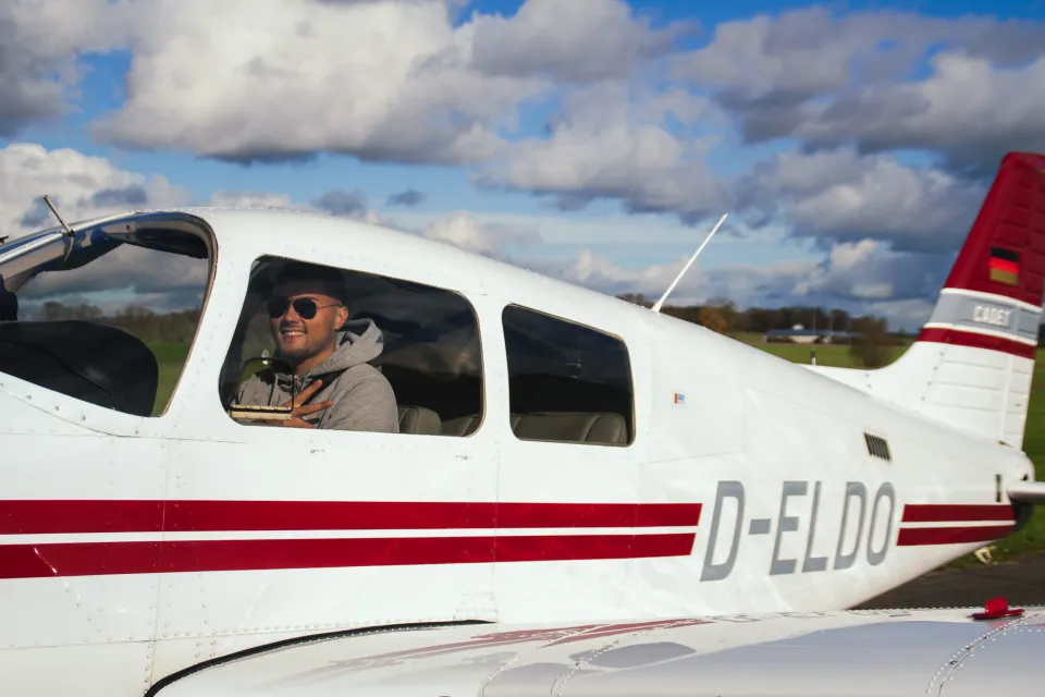 Pilot lächelt aus dem Cockpit der D-ELDO